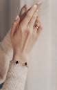 Woman wearing elegant golden engagement ring with diamond on close-up