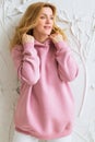 Woman wearing empty pink hoodie and posing against a white wall Royalty Free Stock Photo