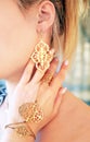 Woman wearing expensive gold jewelry - golden bracelet ring and earings Royalty Free Stock Photo