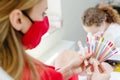 Woman wearing face mask checking colors for toenail pedicure