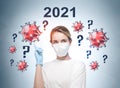 Woman wearing face mask because of coronavirus, covid-19, pandemic in the world and pointing out the sketched virus over question Royalty Free Stock Photo