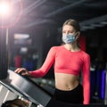 Woman wearing face mask exercise workout in gym during corona virus pandermic Royalty Free Stock Photo