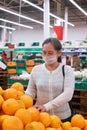 Woman wearing face mask  shopping and choosing  products in supermarket Royalty Free Stock Photo