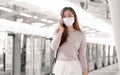 Woman wearing face mask and talking on mobile phone while standing on railway station Royalty Free Stock Photo