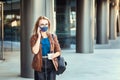 Woman wearing face mask talking on phone outdoor while commuting Royalty Free Stock Photo