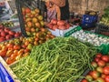 woman wearing gloves moving tomatoes to market stall