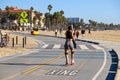 A woman wearing gray shorts and a black tank top roller staking on a smooth winding bike path at the beach Royalty Free Stock Photo