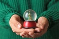 Woman wearing green sweater holding snow globe with Christmas tree Royalty Free Stock Photo