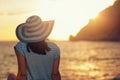 Woman wearing hat admire the sunset over the sea Royalty Free Stock Photo