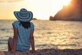 Woman wearing hat admire the sunset over the sea Royalty Free Stock Photo