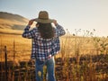 Woman wearing hat from behind looking at view of rural california landscape Royalty Free Stock Photo