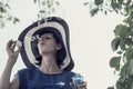 Woman wearing hat blowing bubbles under tree Royalty Free Stock Photo