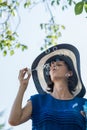 Woman wearing hat with blue dress blowing bubbles Royalty Free Stock Photo