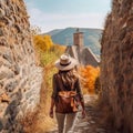 a woman with a hat walking down a medieval path