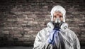 Woman Wearing Hazmat Suit, Protective Gas Mask and Goggles Against Brick Wall Royalty Free Stock Photo