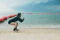 woman wearing headphone approching for squat exercise at sea beach Royalty Free Stock Photo