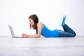 Woman wearing headphones lying on the floor with laptop Royalty Free Stock Photo