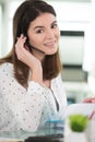 woman wearing headset sat at office desk Royalty Free Stock Photo