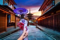 Woman wearing japanese traditional kimono holding man`s hand and leading him to Yasaka Pagoda and Sannen Zaka Street in Kyoto