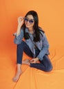 Woman wearing jeans on black background orange background