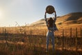 Woman wearing jeans and flannel from behind looking at view of rural california landscape holding up hat in air Royalty Free Stock Photo