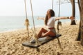 Woman wearing jeans shorts relax on the swing on the beach Royalty Free Stock Photo