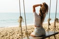 Woman wearing jeans shorts relax on the swing on the beach Royalty Free Stock Photo