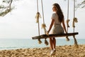 Woman wearing jeans shorts relax on the swing on the beach Royalty Free Stock Photo