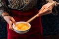Woman wearing kimono is beating hen egg with chopsticks for dipping with sukiyaki beef