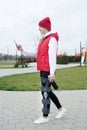 Woman wearing knee brace or orthosis after leg surgery walking in the park using smartphone
