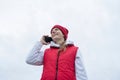 Woman wearing knee brace or orthosis after leg surgery walking in the park using smartphone