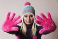 Woman wearing a knitted cap stretching her hands in front of her