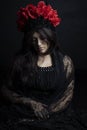Woman wearing lace dress with a red rose headdress against a black backdrop Royalty Free Stock Photo