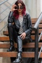 a woman wearing leather pants and black jacket sits on the steps Royalty Free Stock Photo