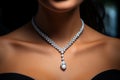 Woman wearing luxury jewelry, platinum necklace with diamonds close-up. Golden necklace on female neck. Beautiful diamond pendant