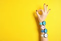 Woman wearing many bright wrist watches on color background, closeup view with space for text. Royalty Free Stock Photo