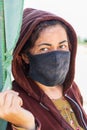 Woman wearing a mask, at a field where pears are being prepared and dried in the sun