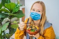 Woman wearing a medical mask during COVID-19 coronavirus eating Raw Organic Poke Bowl with Rice and Veggies close-up on Royalty Free Stock Photo