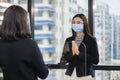 Woman wearing medical mask and face shield protect against airborne disease visitor greeting Wai Thai Greetings.