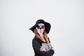 woman wearing mexican face mask during halloween celebration. skeleton costume and black stylish hat. woman with arms crossed.