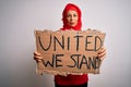 Woman wearing muslim hijab asking for union holding banner with united stand message with a confident expression on smart face