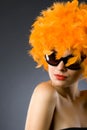 Woman wearing an orange feather wig and sunglasses Royalty Free Stock Photo