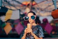 Woman Wearing Oversized Party Glasses Sipping from a Plastic Cup Royalty Free Stock Photo