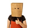 Woman wearing paper bag over her head giving thumbs up with left hand
