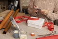 Woman wearing pink winter sweater and using mobile phone to buy,send christmas presents.Wrapping and sending gifts online.Wooden t