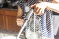A woman wearing polka dot pattern summer dress is filling up a glass electrical kettle Royalty Free Stock Photo