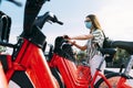 Woman wearing protective face mask taking a rented electric bicycle. Taking an electric bike.