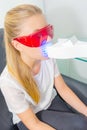 Woman wearing protective glasses having treatment on teeth