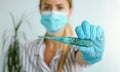 Woman wearing protective mask and gloves holding digital thermometer in hand. Selective focus. Coronavirus symptoms Royalty Free Stock Photo