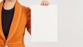 Woman is wearing a Radian Yellow suit and holding the blank A4 paper board on white background. Body part